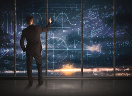 Businessman drawing business graphs on glass wall
