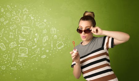 Cute girl blowing hand drawn media icons and symbols on green background