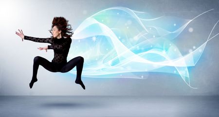 Cute teenager jumping with abstract blue scarf around her concept on background