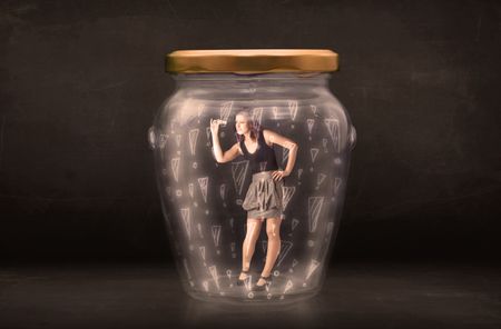 Business woman trapped in jar with exclamation marks concept on bakcground