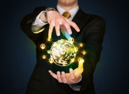 Businessman holding a shining globe with social media connection
