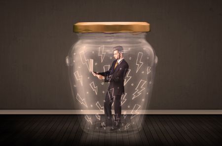 Businessman inside a glass jar with lightning drawings concept on background