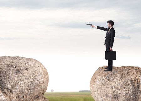 Young businessman standing on edge of rock mountain