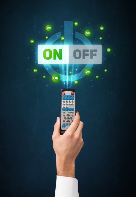 Hand holding a remote control, on-off signal coming out of it
