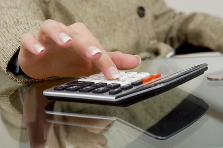 Close up of a businesswoman using a calculator.