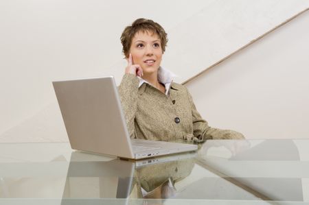 Business woman thinking in front of computer.