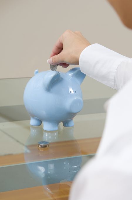 Woman putting money into piggy bank.