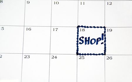 SHOP! written in blue on one day of white monthly calendar (close-up)
