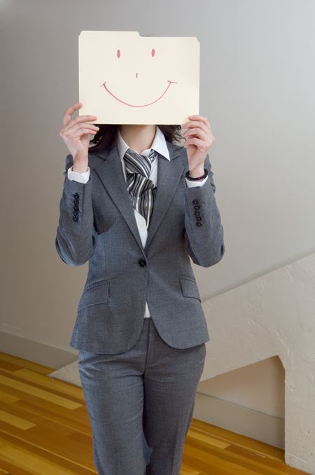 Happy businesswoman with folder in front of her face.