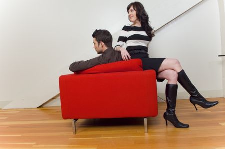 couple hanging out in red chair.