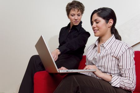 Two businesswomen looking at laptop.