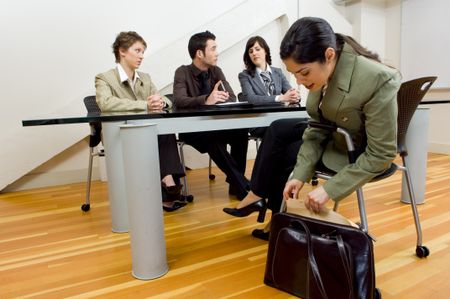 Woman pulling resume out of briefcase at interview.