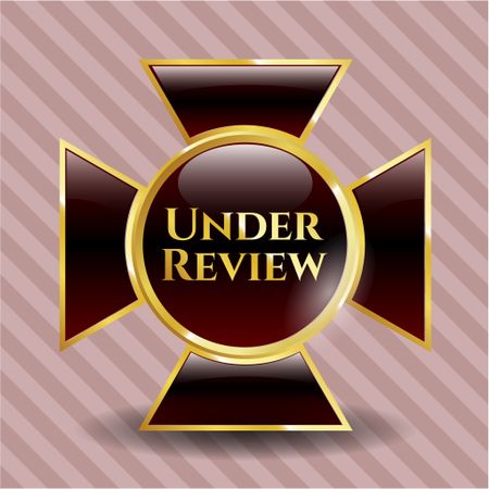 Under Review gold shiny emblem