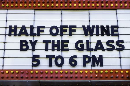 Happy hour in a tourist town: Daily bargain on wine announced on a vintage movie marquee on a main street in America