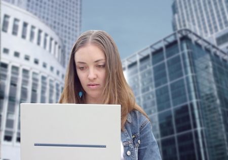 attractive casual girl using a laptop in a financial district