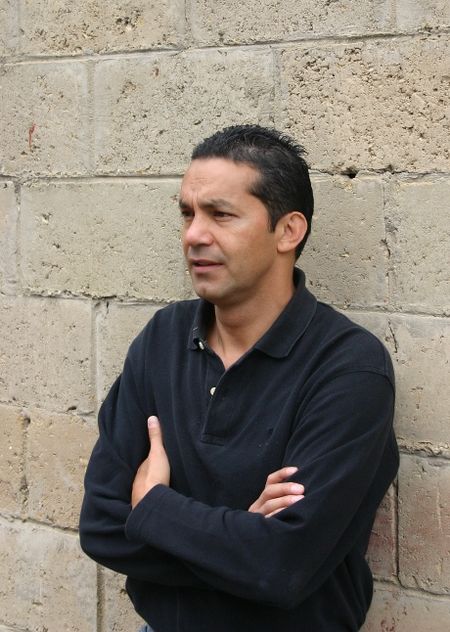 casual guy with arms crossed in front of a concrete wall
