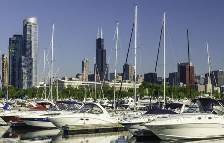 Urban marina skyline: Yachts in Burnham Harbor in Chicago, Illinois, USA, with landmarks (including Willis Tower, once the tallest building in the world) in the distance, early in June