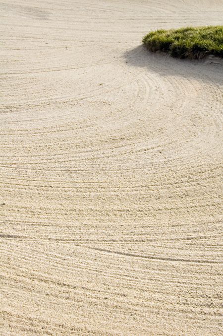 Rake marks in sand of fairway bunker on golf course