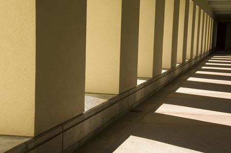 Interplay of sunlight and shadow along passageway outside university building