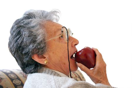 elderly woman eating an apple