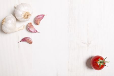 Fresh raw garlic on a light wooden kitchen work surface