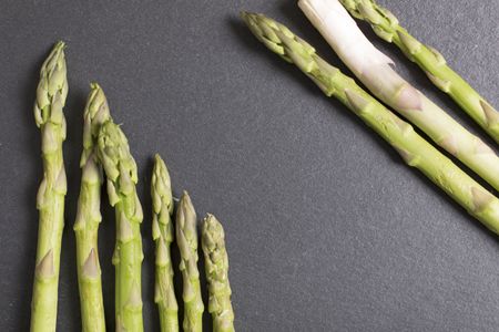 Selection of fresh Asparagus on black slate with copy space