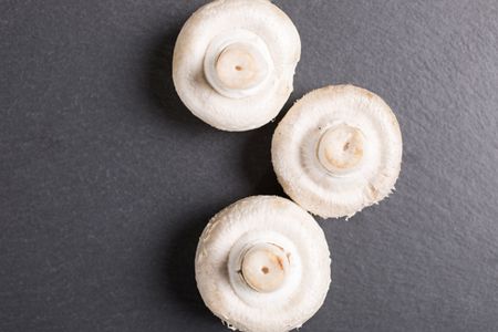 Fresh raw mushrooms on black slate