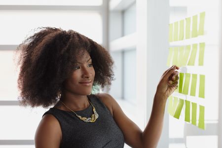 Portrait of a smiling business woman with an afro in bright glass office