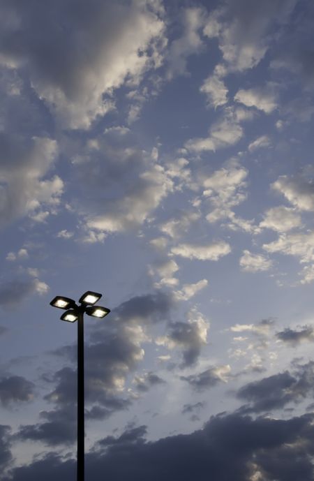 Four lights on pole in silhouette at sunset