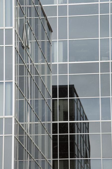 Skyscraper reflections in light snow, one window open, on college campus