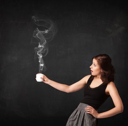 Businesswoman standing and holding a white steamy cup on a black background