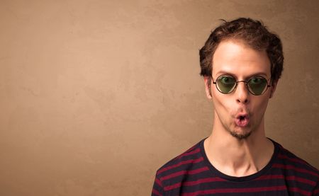 portrait-young-pretty-man-sunglasses-copyspace-308823074 Portrait of a young pretty man with sunglasses and copyspace on brown background