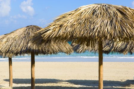 Grass huts on a tropical sandy beach