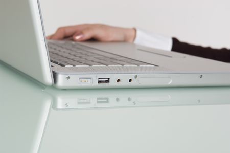 Hand beside a laptop.