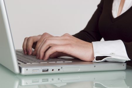 Close up of a business woman working at a laptop.