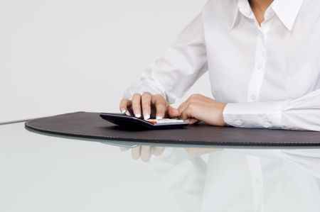 Close up of a businesswoman using a calculator.