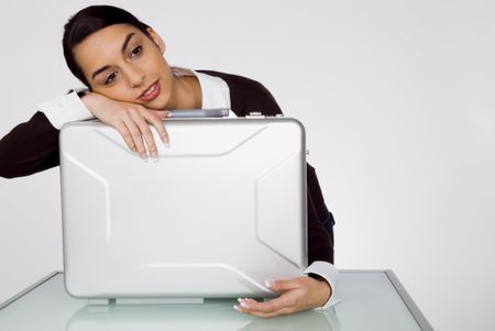 businesswoman leaning tired on brief case.