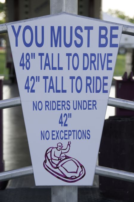Height-requirement sign outside carnival ride