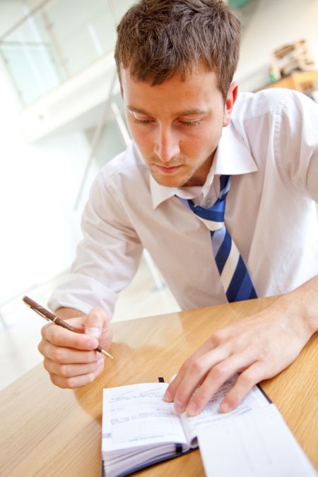 Business man writing an appointment on his agenda