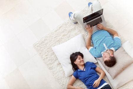 Beautiful couple smiling lying on the floor