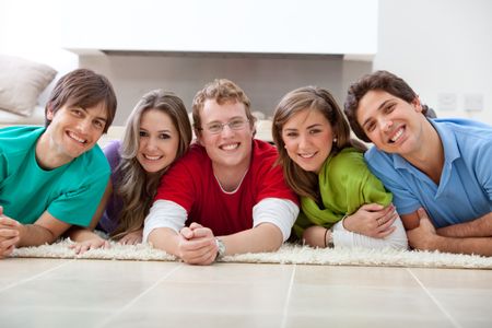 Happy group of friends smiling together on the floor