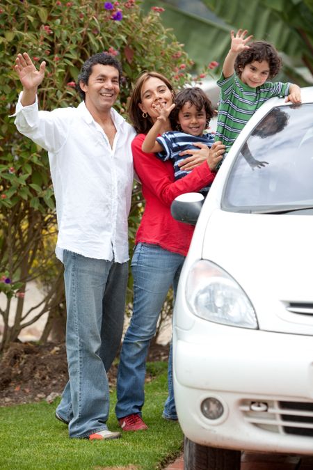 Lovely family waving and smiling from the car