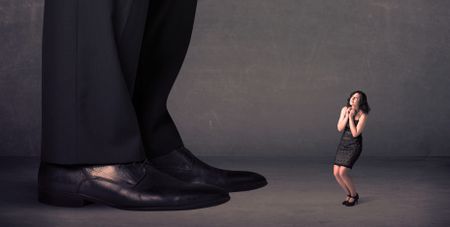 Huge legs with small businesswoman standing in front concept on background