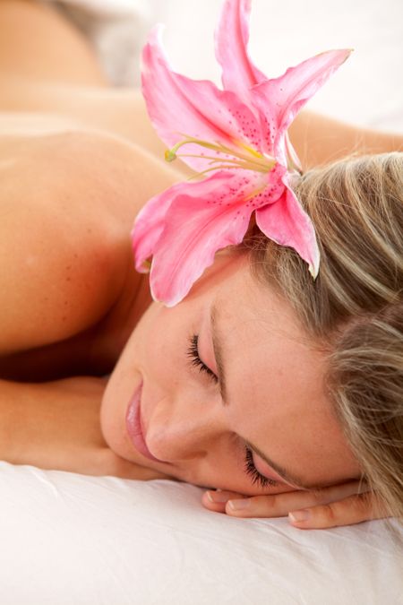 Woman with a flower on her head relaxing at a spa