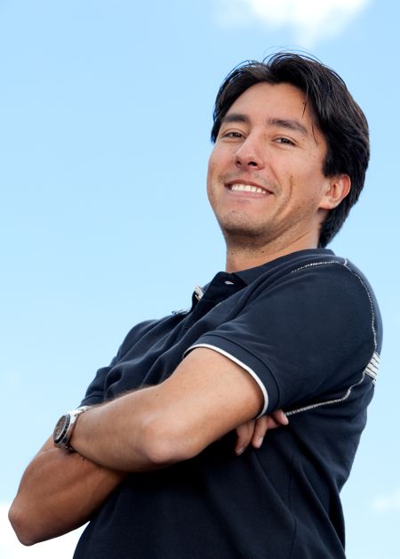 Attractive male's portrait smiling over a blue sky