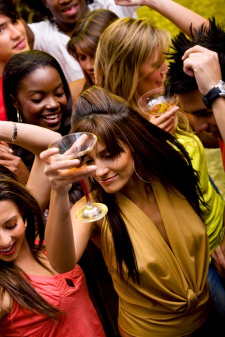 group of happy friends dancing in a nightclub