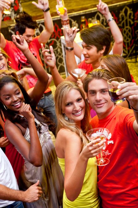 Group of happy friends at a bar or a nightclub toasting