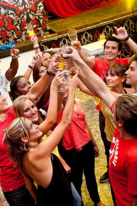 Group of happy friends at a bar toasting