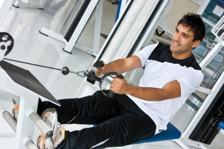 Strong gym man exercising on a machine
