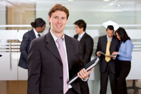 Business man standing at an office holding a portfolio